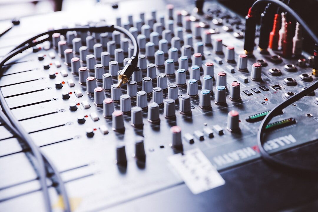 Audio mixing console with sliders and knobs
